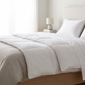 Lit fait comme à l'hôtel avec drap-housse tendu, drap plat replié et oreillers dressés en coton blanc