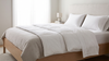 Lit fait comme à l'hôtel avec drap-housse tendu, drap plat replié et oreillers dressés en coton blanc