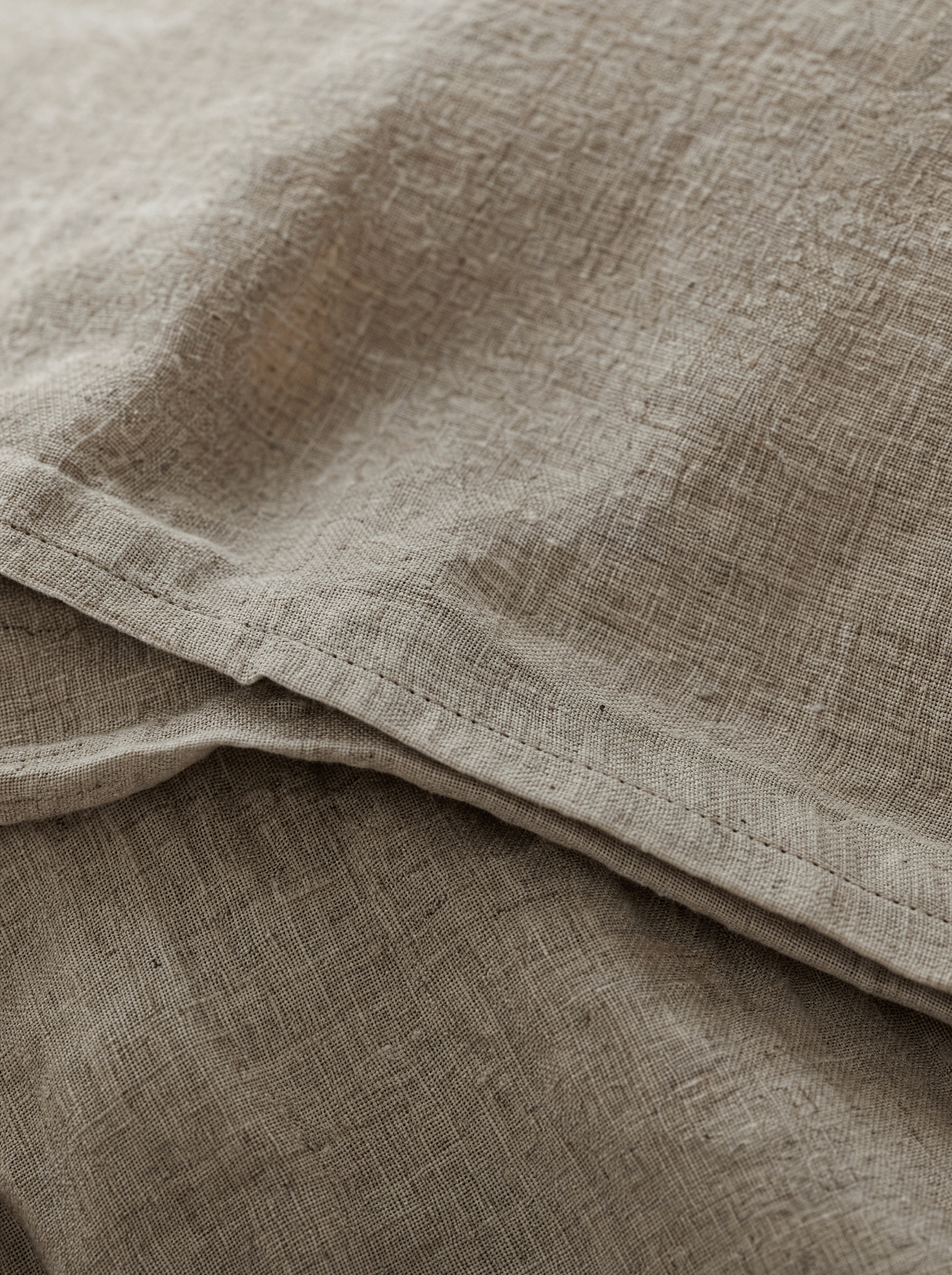 Linge de lit en lin lavé naturel dans une chambre lumineuse Noctua Paris