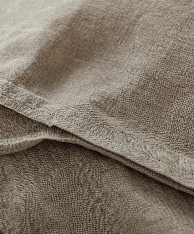 Linge de lit en lin lavé naturel dans une chambre lumineuse Noctua Paris
