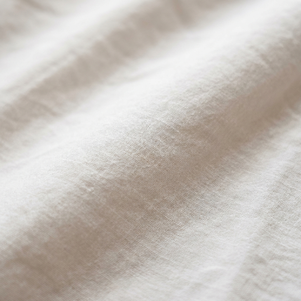 Gros plan macro sur la percale de coton lavé Noctua Paris, toucher mat et sec