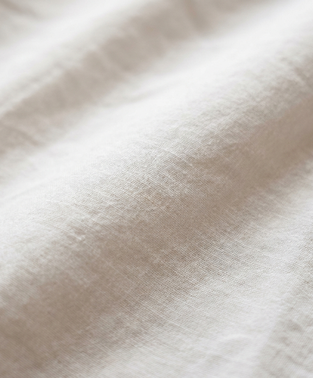 Gros plan macro sur la percale de coton lavé Noctua Paris, toucher mat et sec