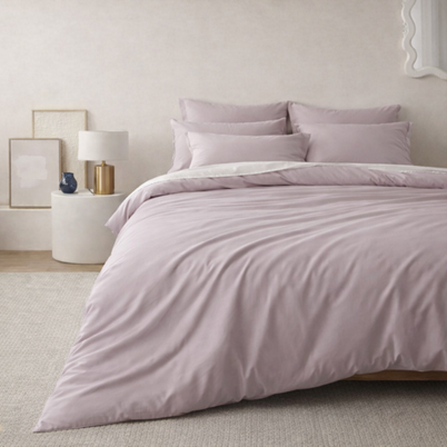 Housse de couette en coton égyptien mauve Noctua Paris sur un lit