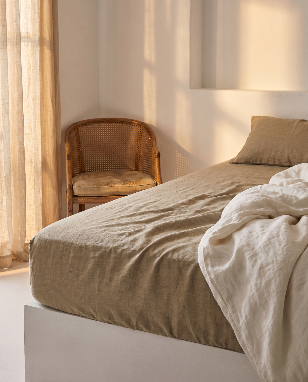 Drap-housse en lin lavé sur un matelas, lumière dorée, Noctua Paris