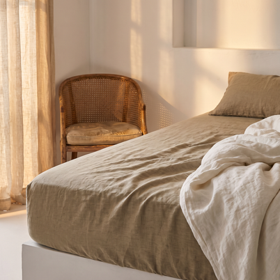 Drap-housse en lin lavé sur un matelas, lumière dorée, Noctua Paris