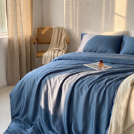 Housse de couette en lyocell d'eucalyptus bleue sur un lit, lumière dorée, Noctua Paris