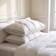 Oreillers plumes et duvet d'oie blancs avec passepoil empilés sur un lit, Noctua Paris
