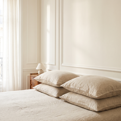 Taies d'oreiller en lin lavé sur un lit, chambre lumineuse, Noctua Paris