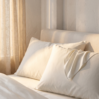 Taies d'oreiller en coton égyptien sateen sur un lit, lumière du soir, Noctua Paris