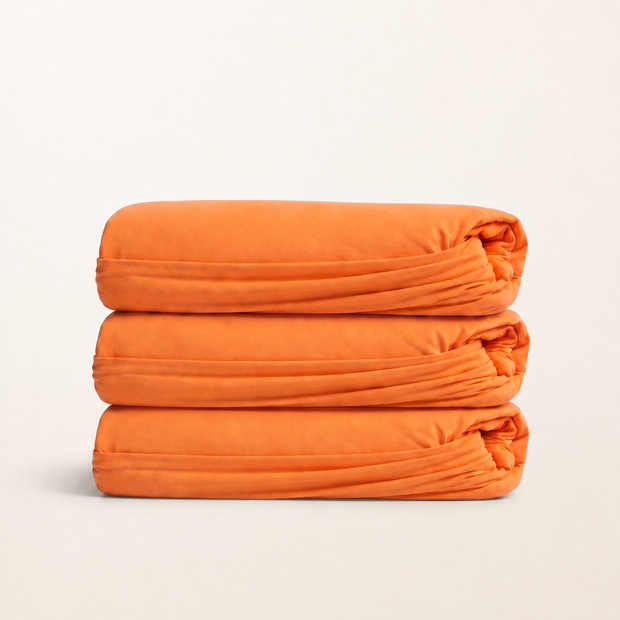 Drap-housse en coton doux orange, packshot sur fond blanc chaud, Noctua Paris