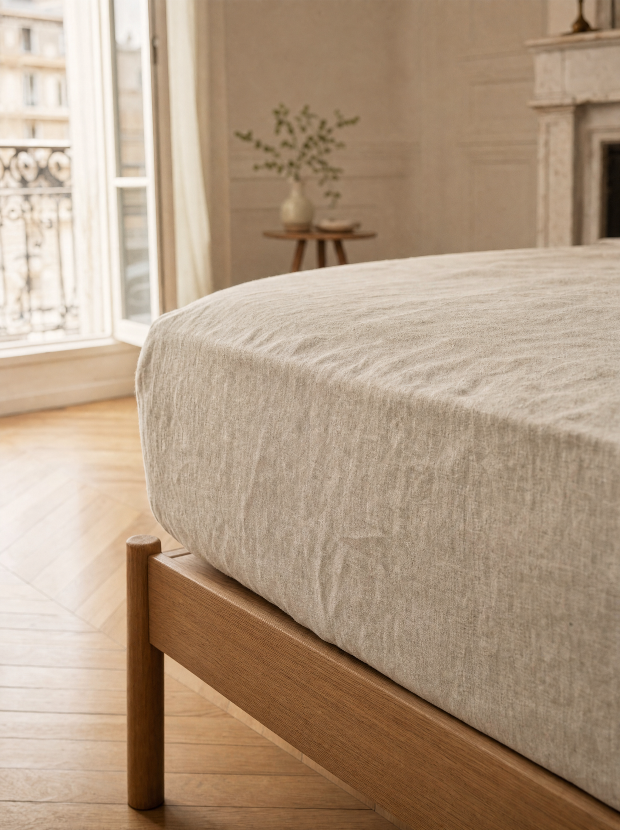 Drap-housse en lin lavé naturel Noctua Paris tendu sur un matelas, coin de lit en chêne clair