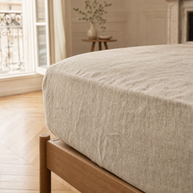 Drap-housse en lin lavé naturel Noctua Paris tendu sur un matelas, coin de lit en chêne clair