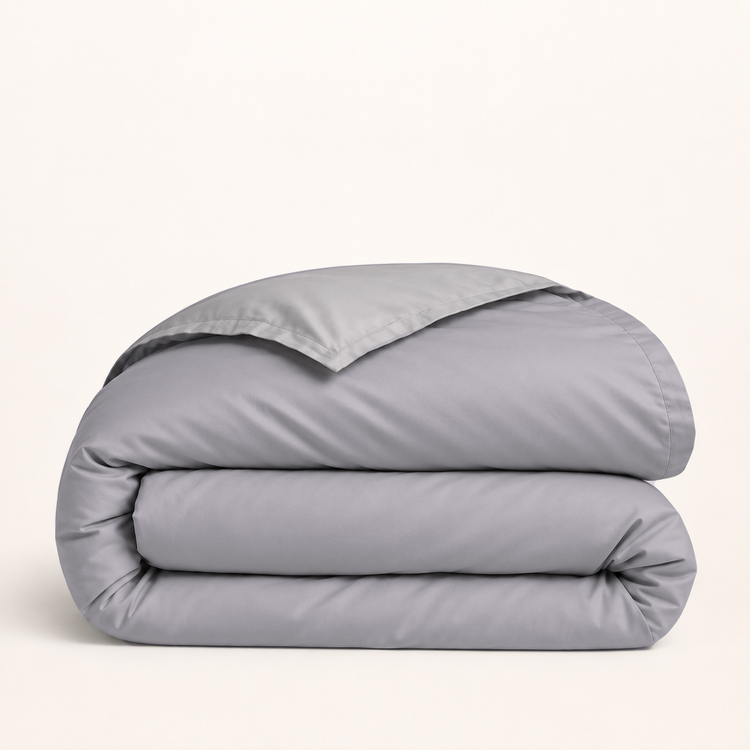 Housse de couette en coton égyptien mauve grisé — housse seule pliée, revers gris, fond ivoire — Noctua Paris.