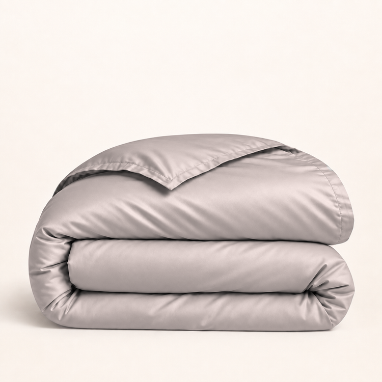 Housse de couette Lyocell d’eucalyptus rose clair — housse seule pliée sur fond ivoire — Noctua Paris.