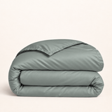 Housse de couette Lyocell d’eucalyptus vert sauge — housse seule pliée sur fond ivoire — Noctua Paris.