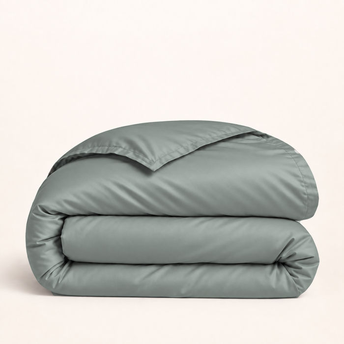 Housse de couette Lyocell d’eucalyptus vert sauge — housse seule pliée sur fond ivoire — Noctua Paris.