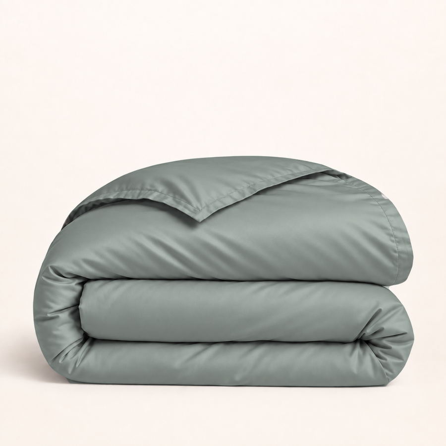Housse de couette Lyocell d’eucalyptus vert sauge — housse seule pliée sur fond ivoire — Noctua Paris.