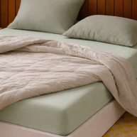 Drap-housse en coton doux vert sauge Noctua Paris dans une chambre minimaliste