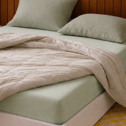 Drap-housse en coton doux vert sauge Noctua Paris dans une chambre minimaliste