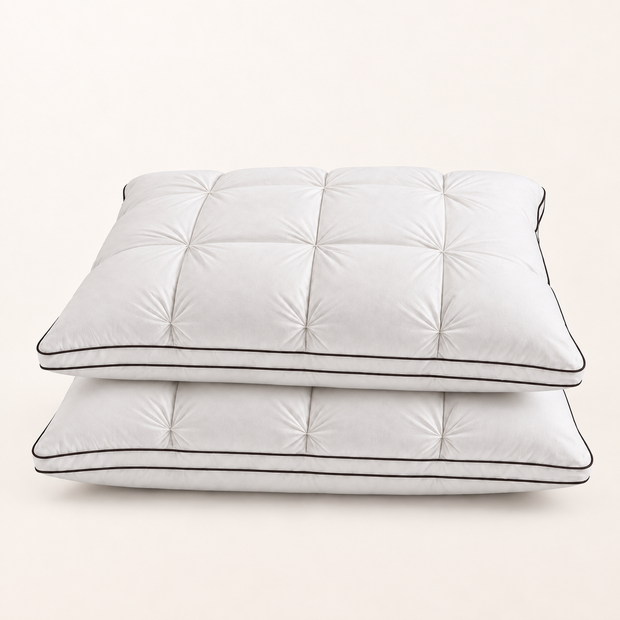 Lot de deux oreillers plumes et duvet d’oie 50 × 70 cm, blancs et capitonnés, empilés sur fond blanc chaud — Noctua Paris
