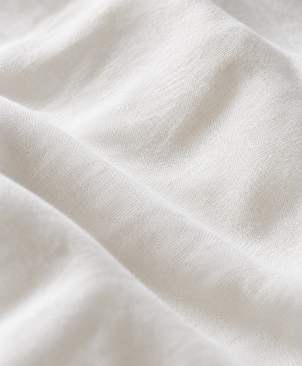 Gros plan de percale de coton lavé blanc Noctua Paris, tissage fin mat et plis doux, sans boutons ni couture.