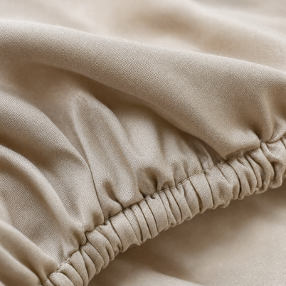 Gros plan macro sur l'élastique et le tissage sateen du drap-housse coton égyptien Noctua Paris