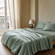 Housse de couette Lyocell eucalyptus vert sauge Noctua Paris sur un lit, chambre parisienne baignée de lumière