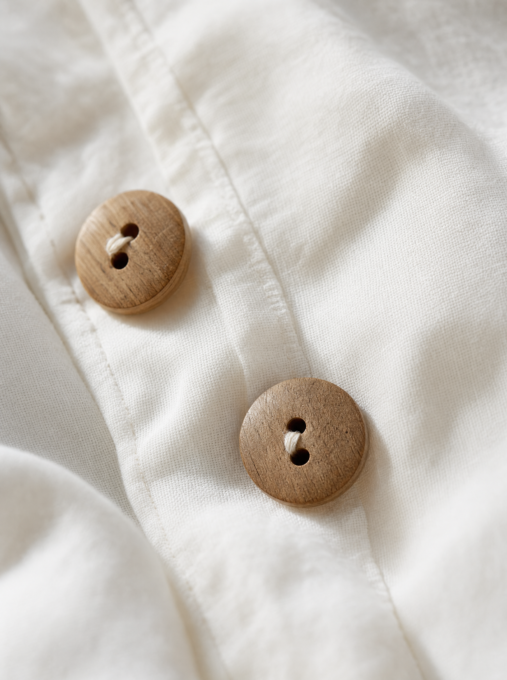 Gros plan sur les boutons en bois naturel et le tissage de la percale de coton lavé Noctua Paris