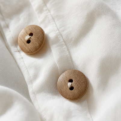 Gros plan sur les boutons en bois naturel et le tissage de la percale de coton lavé Noctua Paris