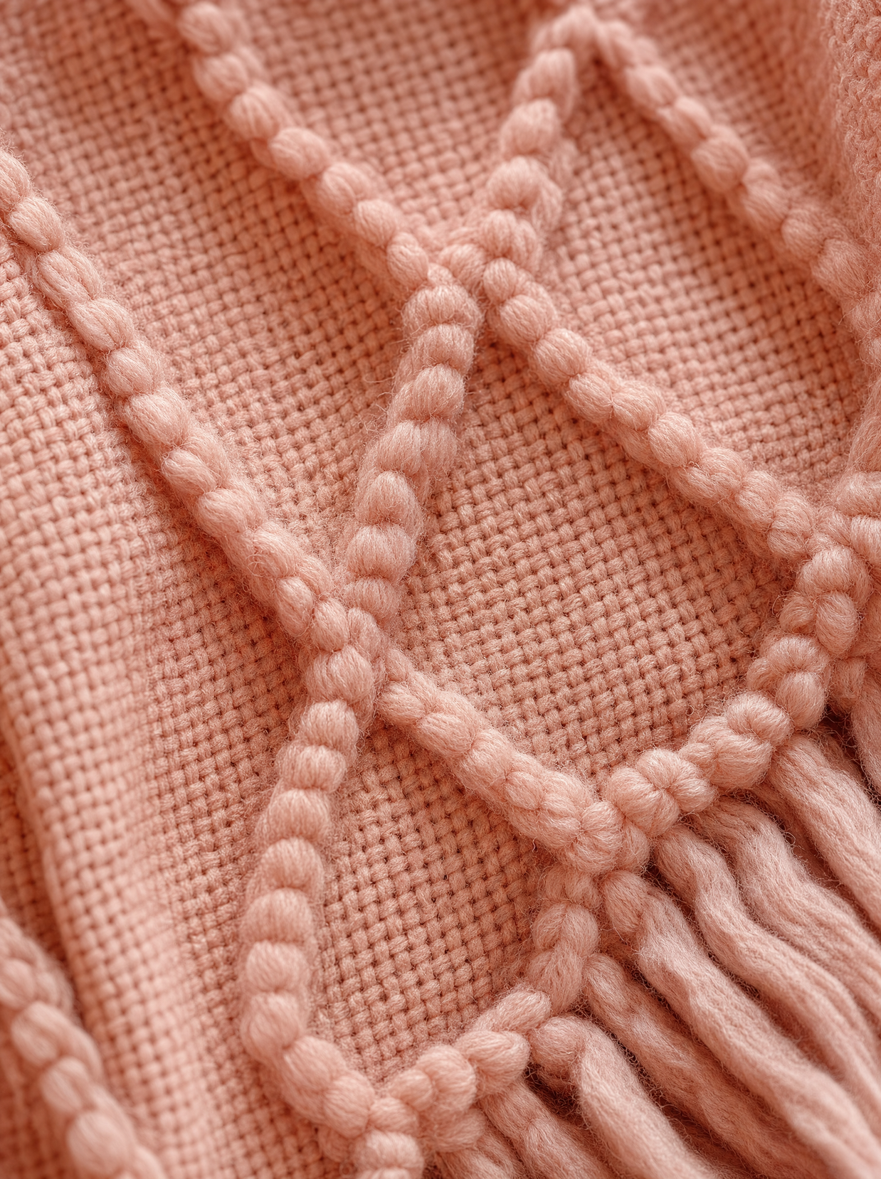 Gros plan macro sur la maille losange en relief du plaid rose Noctua Paris