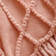 Gros plan macro sur la maille losange en relief du plaid rose Noctua Paris