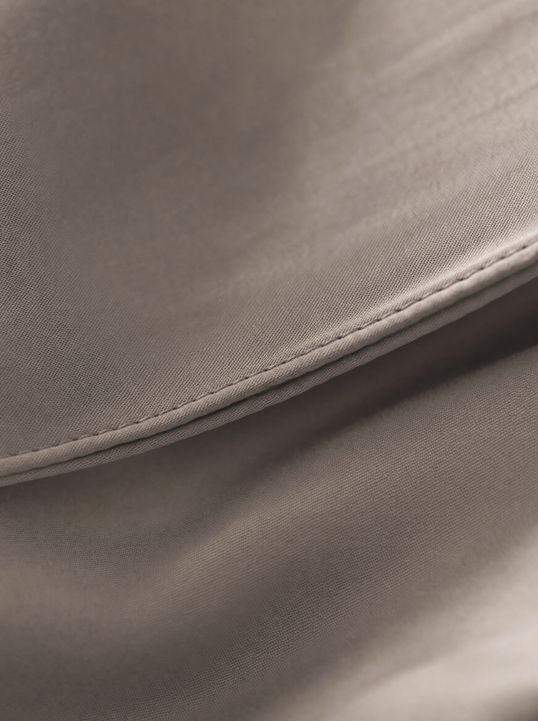 Gros plan macro sur le tissage sateen du coton égyptien taupe Noctua Paris