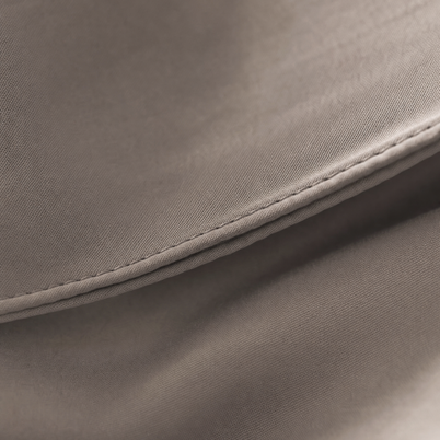 Gros plan macro sur le tissage sateen du coton égyptien taupe Noctua Paris