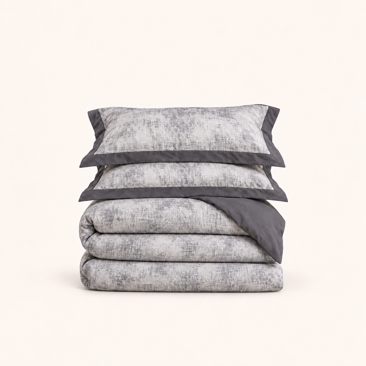 Noctua Paris — Parure de lit en gaze de coton gris, deux taies à bordure unie et housse pliée, sur fond ivoire.