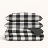 Parure Vichy réversible noir et blanc — grands carreaux, revers uni anthracite, deux taies et une housse pliée, sans drap ni étiquette.
