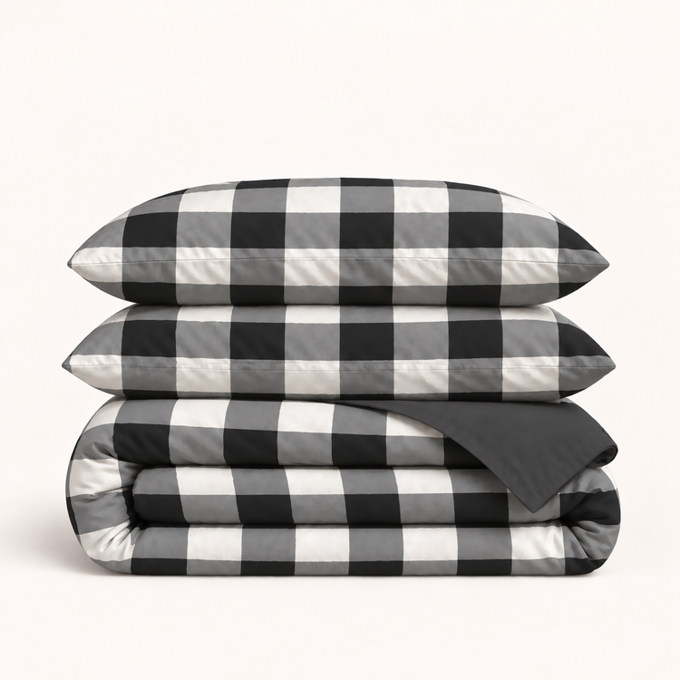 Parure Vichy réversible noir et blanc — grands carreaux, revers uni anthracite, deux taies et une housse pliée, sans drap ni étiquette.