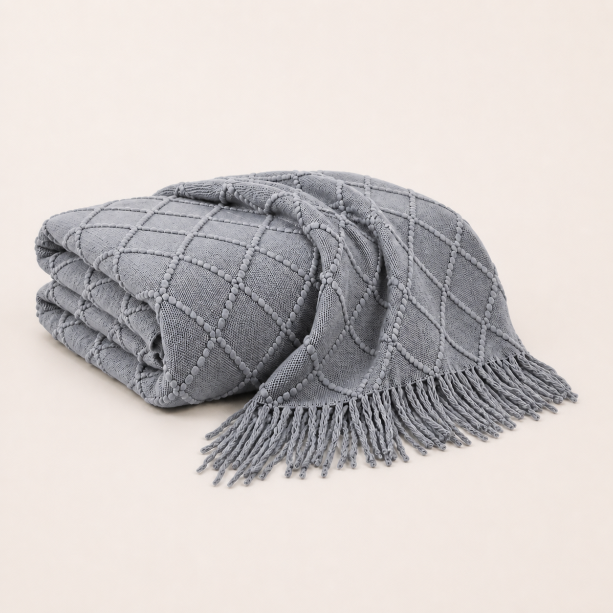 Plaid en maille à franges gris clair plié sur fond blanc chaud Noctua Paris