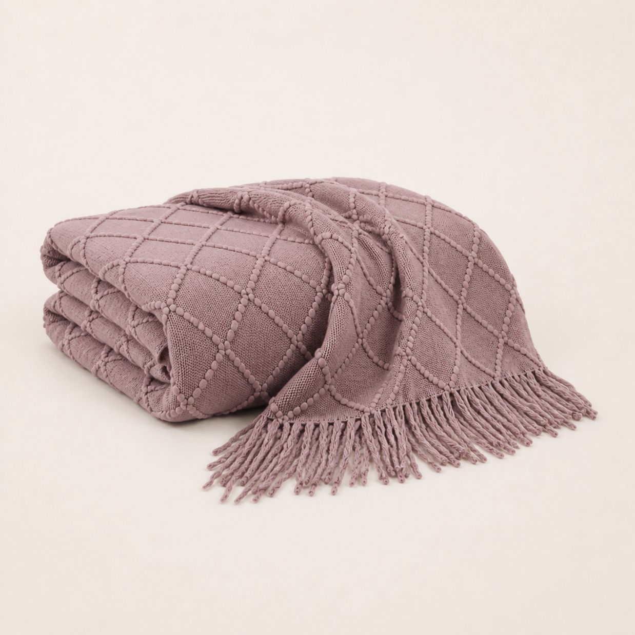 Plaid en maille à franges rose plié sur fond blanc chaud Noctua Paris