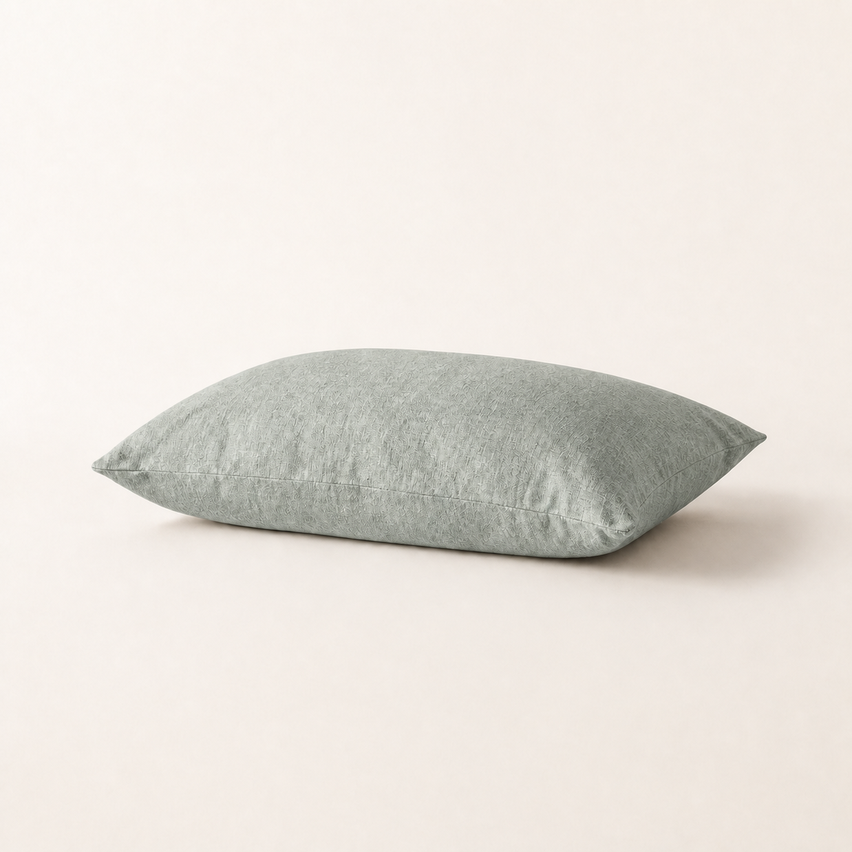 Taie d'oreiller en lin lavé vert sauge, packshot horizontal sur fond blanc chaud, Noctua Paris